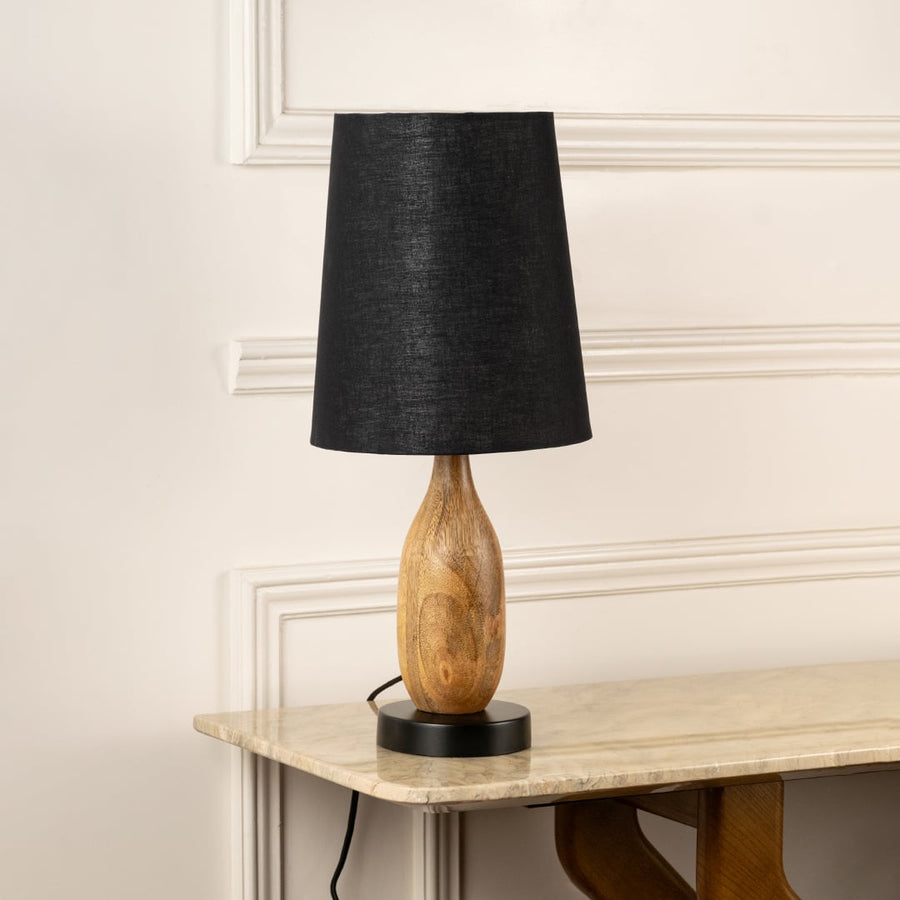 Black fabric shade table lamp with sculpted natural wood base for elegant bedside and living room decor styling.