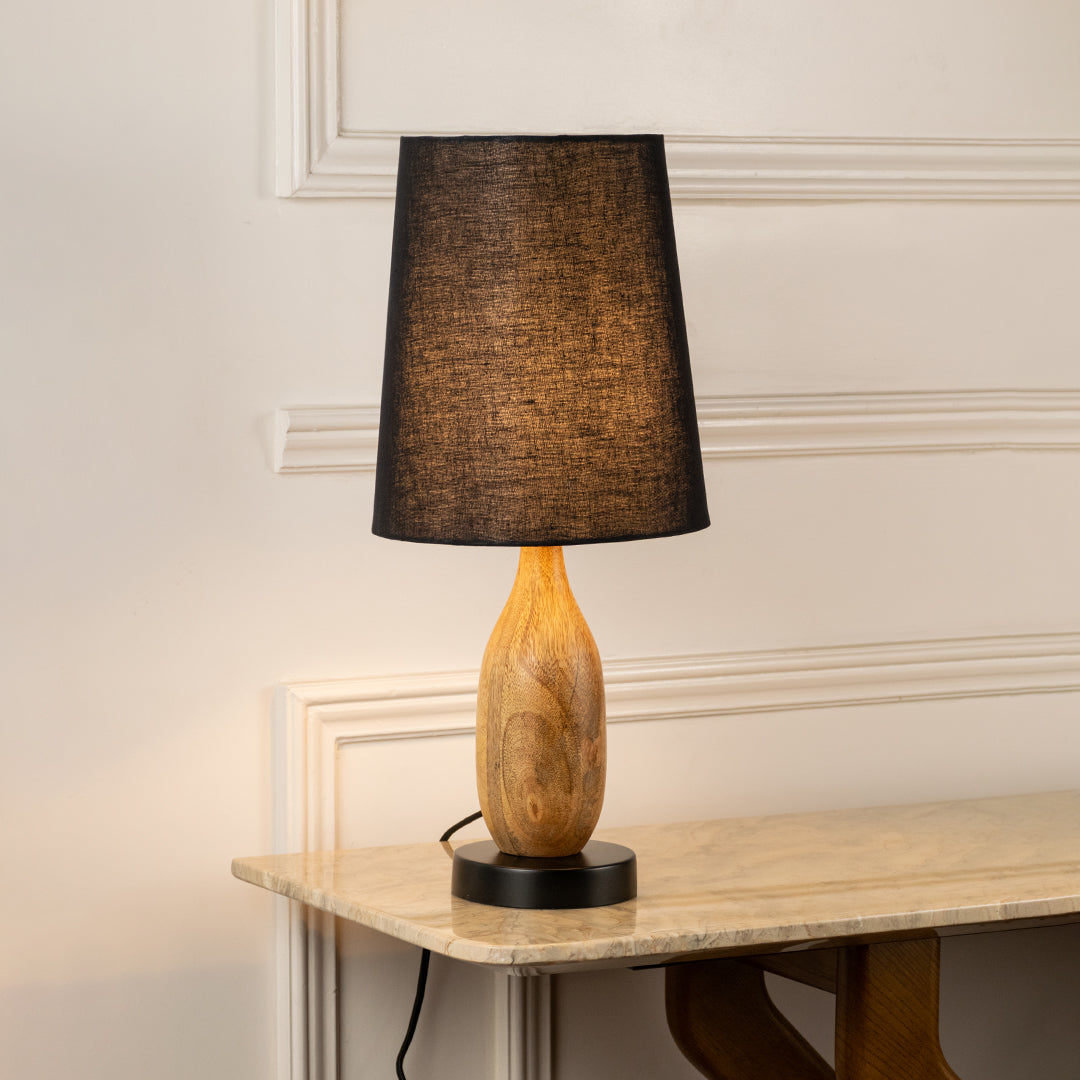 Table lamp with dark fabric shade and wooden base perfect for warm bedroom or living room table decor placement on clean background.