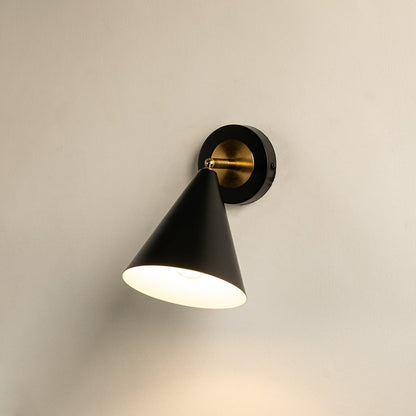 Black and gold conical wall sconce glowing softly against a clean white background showcasing modern minimalist lighting design for elegant home decor.