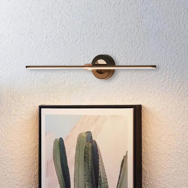 Black and gold metal picture light illuminating framed artwork with warm focused lighting for elegant gallery style decor.