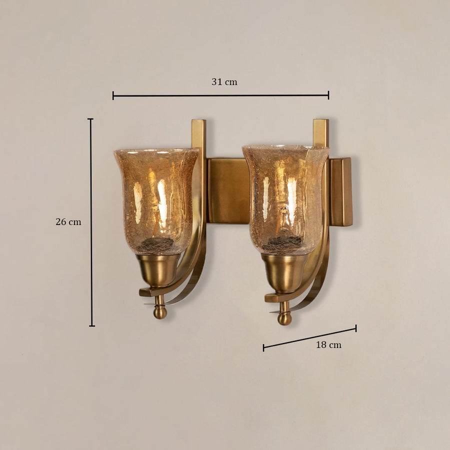 Modern brass double wall sconce with amber glass shades measuring 26cm height 31cm width and 18cm projection specifications.