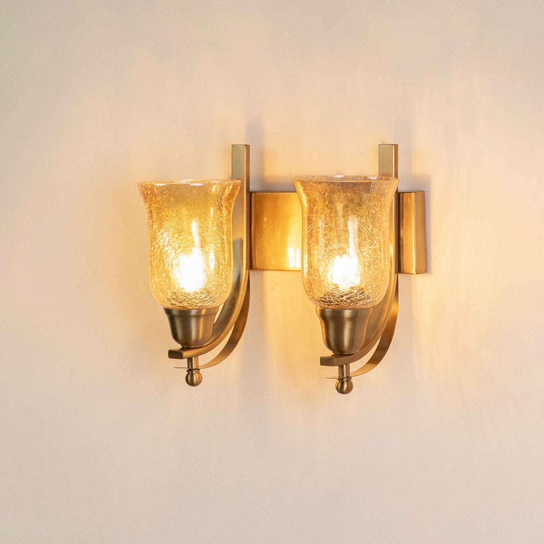 Gold metal wall light with dual glass shades on white background perfect for bedroom living room and hallway decor.