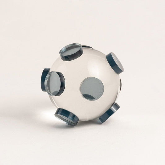 Clear glass orb sculpture with grey circular accents displayed on white background for modern home styling.