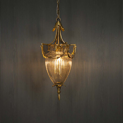 Glowing antique brass glass lantern turned on suspended against a dark black background highlighting the warm light emission.