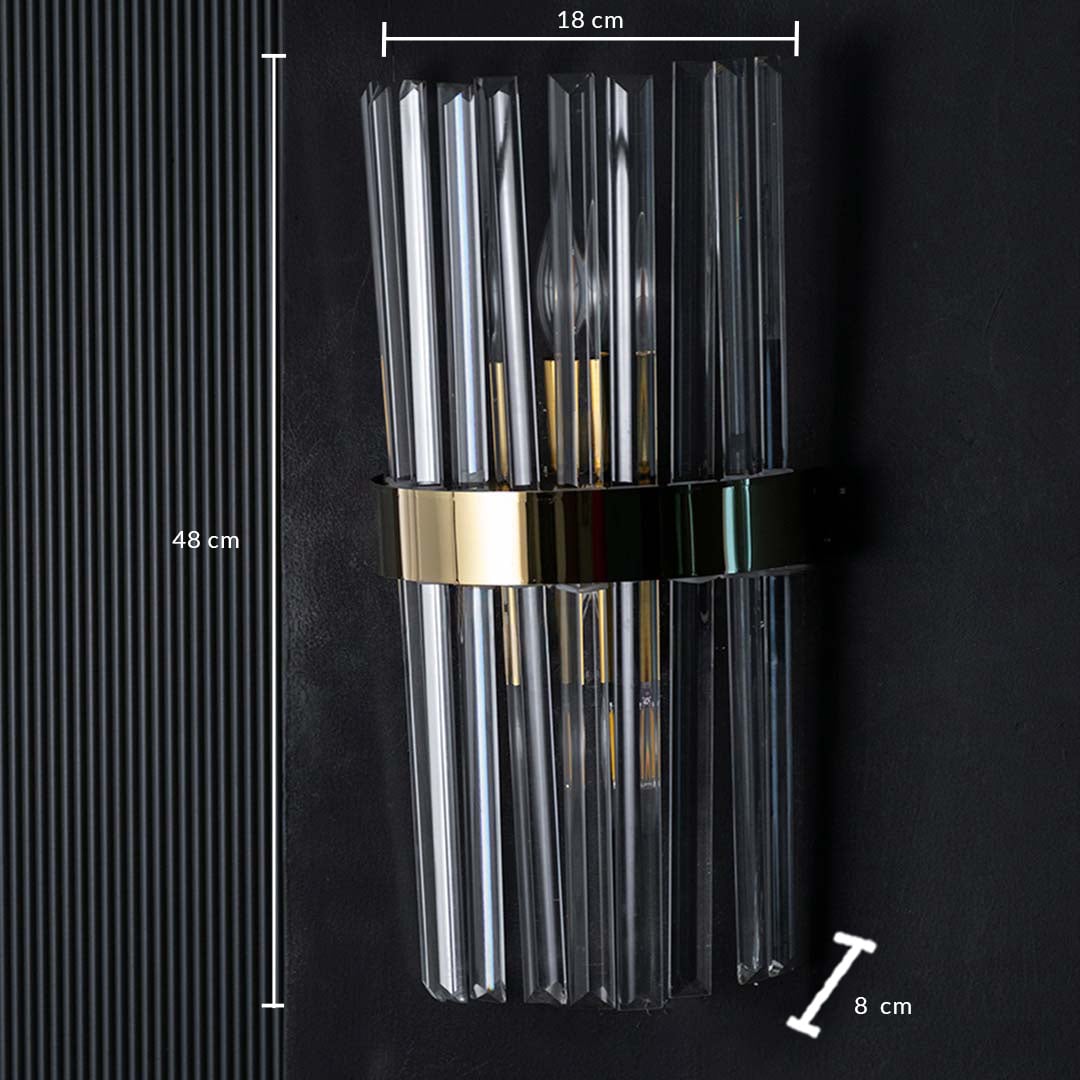 Crystal wall light shown with dimensions measuring 48 cm in height 18 cm in width and 8 cm in depth with clear rods and a polished gold band.