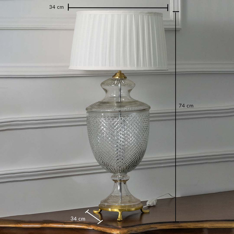 Glass table lamp with brass base and white pleated shade shown on white background featuring height 74 cm and width 34 cm for precise sizing.