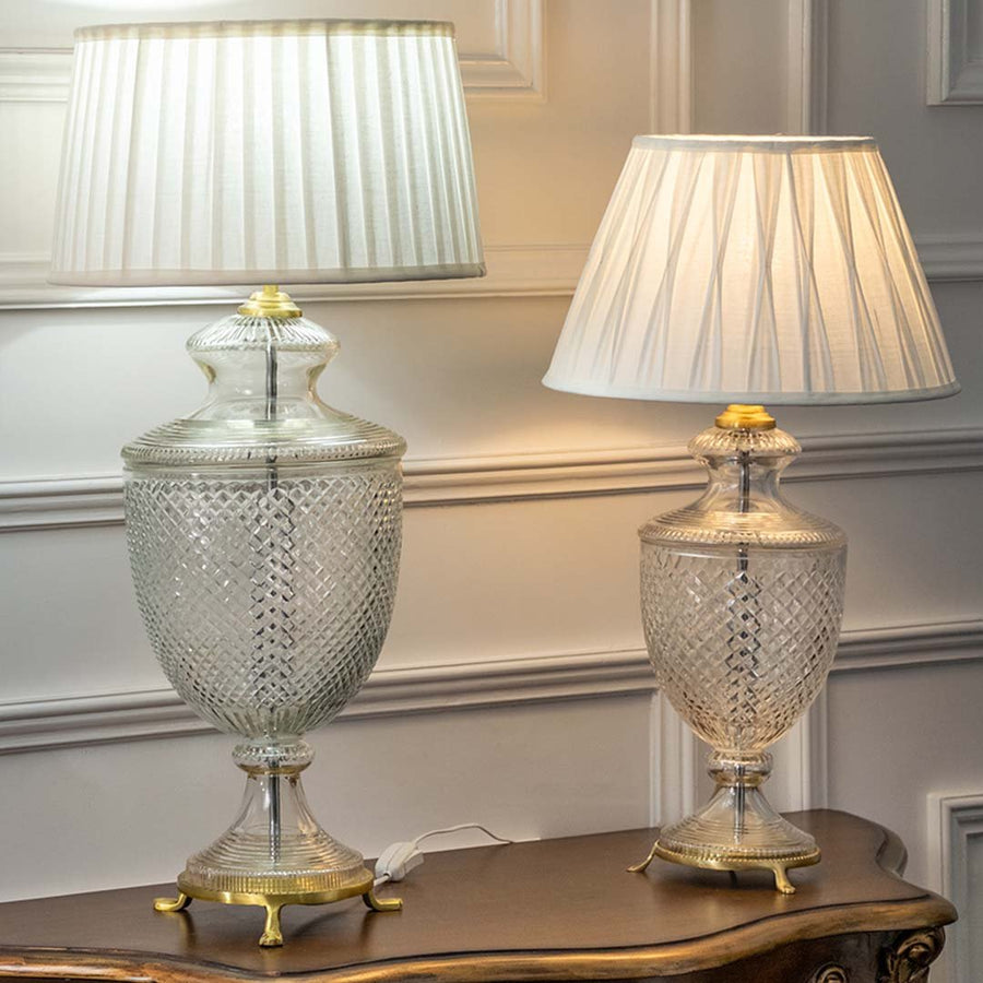 Decorative clear etched glass table lamps with pleated fabric shades adding refined classic decor and ambient lighting.