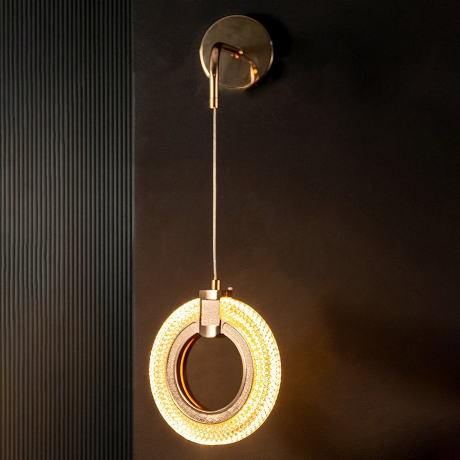 Modern gold crystal wall light turned on glowing against black wall creating premium decor look.