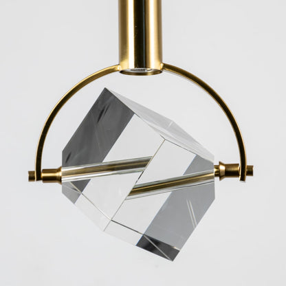 Closeup of crystal cube pendant light with golden arch frame and clear glass design for luxury home interiors.