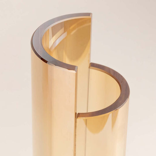 Closeup of amber glass decorative vase with curved layered design showcasing premium craftsmanship and modern styling.