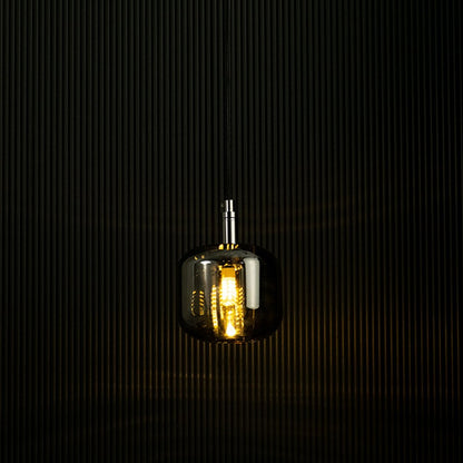 Amber glass pendant light glowing against a dark backdrop showcasing its elegant design and warm lighting effect.