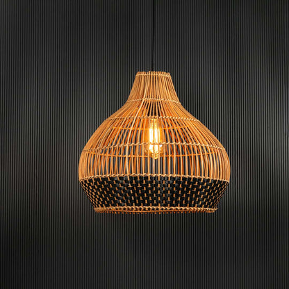 Rattan pendant light glowing softly on black background emphasizing its woven pattern and warm ambience.