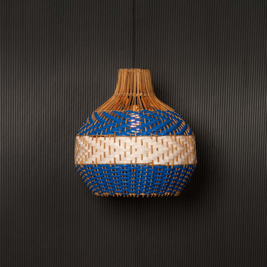 Blue and natural rattan pendant light on black background highlighting elegant craftsmanship and texture.