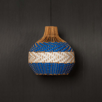 Blue and natural rattan pendant light on black background highlighting its woven texture and elegant handcrafted design.