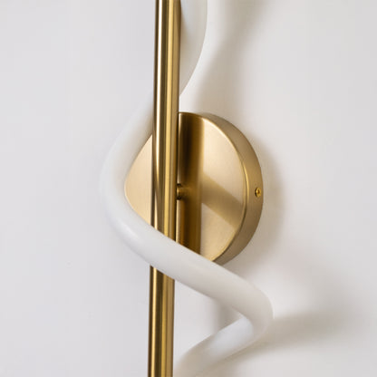 Closeup wall light in gold metal finish with sculpted white tube design for bedroom or living decor lighting white background.