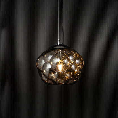 Smokey glass bubble pendant light glowing on black background with artistic round shade for stylish home lighting.
