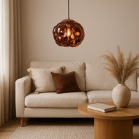 Copper glass pendant light above sofa adding warm ambient lighting and luxurious modern elegance to living room decor.