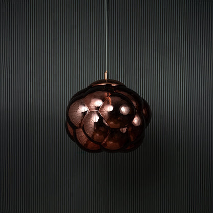 Brown glass bubble pendant light bulb off on black background featuring artistic round shade and modern design.