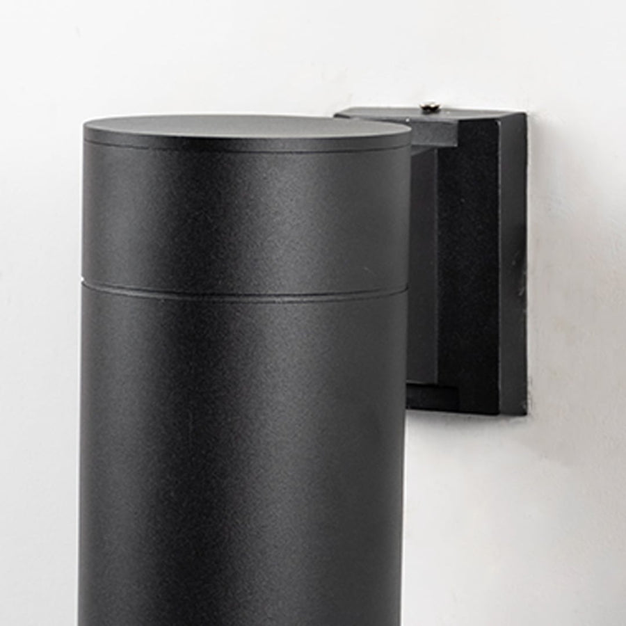 Closeup of black metal cylindrical outdoor wall light showing smooth matte finish and sleek modern design for exterior use.