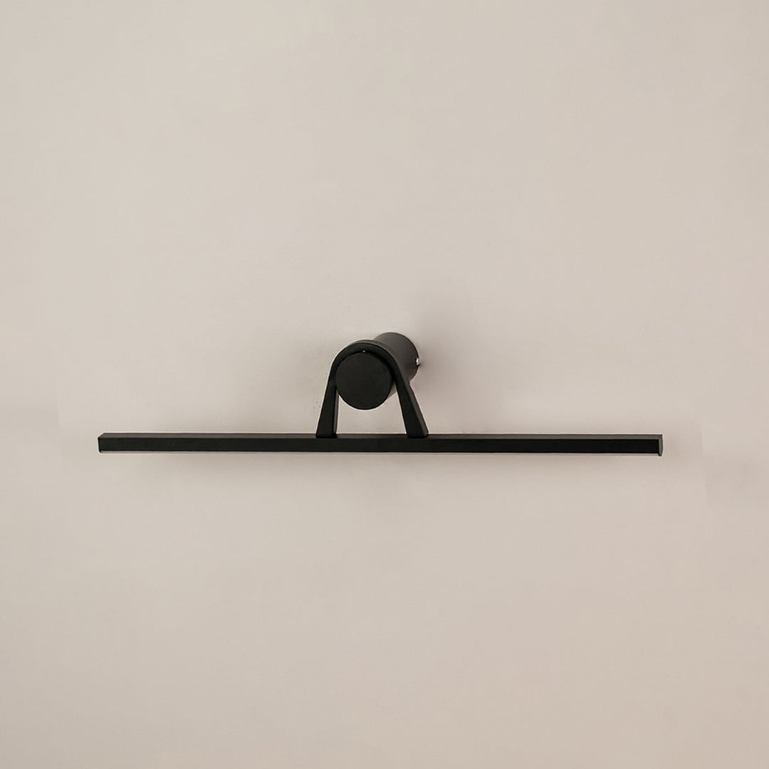 Black metal picture light on a white background with light off highlighting its bold minimal modern design.
