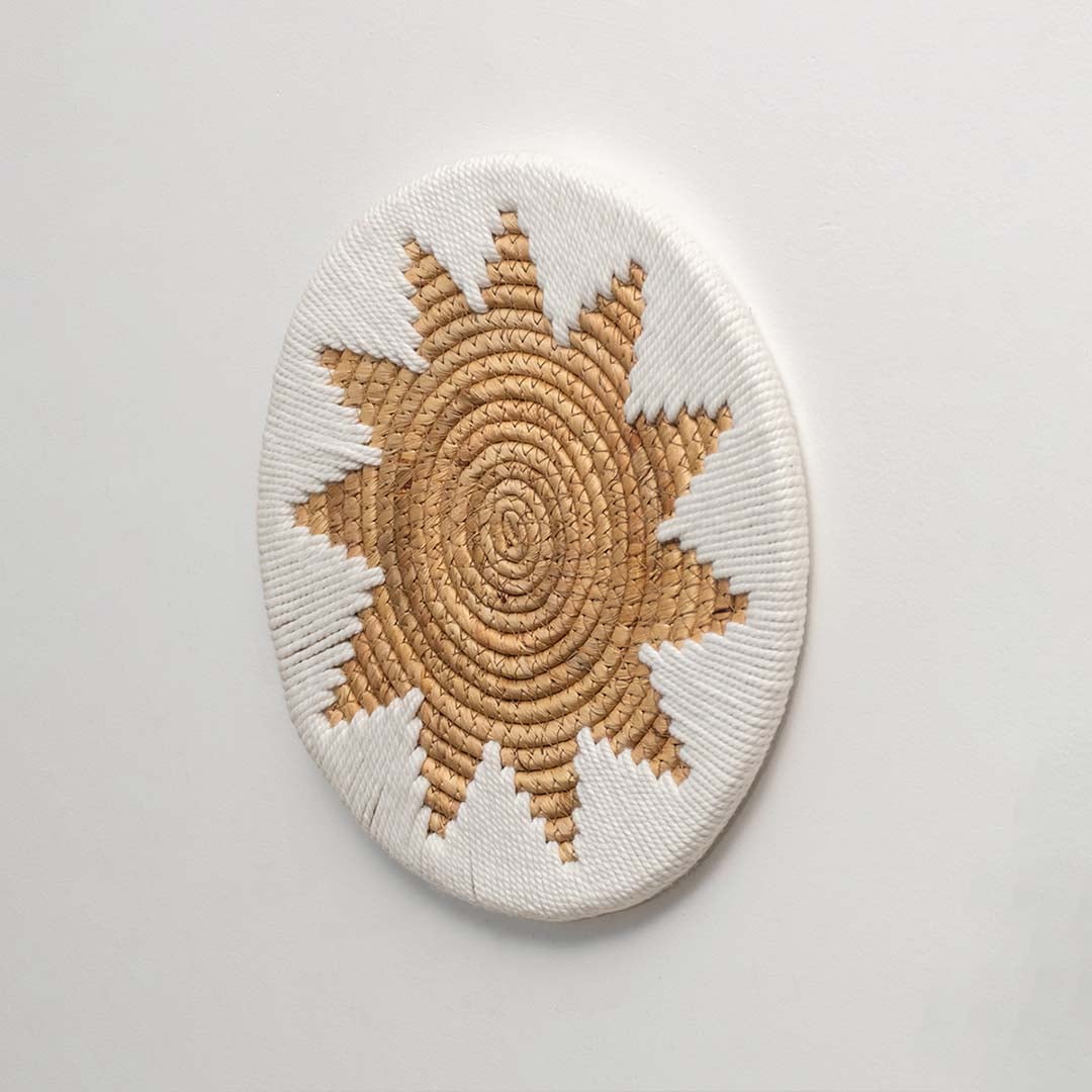 A side angle of a beige and white jute wall decor plate showing its raised woven texture and handcrafted depth for natural home styling.
