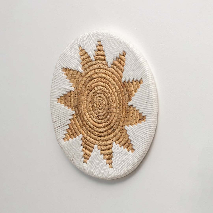 A side angle of a beige and white jute wall decor plate showing its raised woven texture and handcrafted depth for natural home styling.
