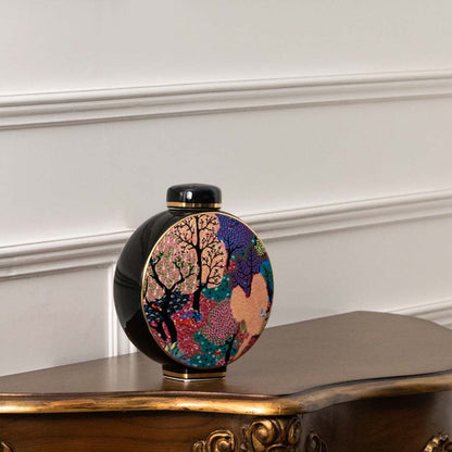 Round vase with pastel and pink floral artwork on black background shown in a closeup view emphasizing color richness brushwork detail and handcrafted décor ideal for designer interiors.