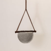 Brown metal pendant light with smoke glass diffuser illuminated to display elegant ceiling lighting.