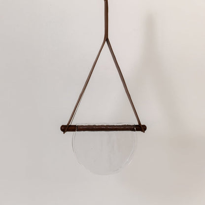 Pendant light with clear half-moon textured glass shade shown turned off against a white background highlighting its simple elegant design.
