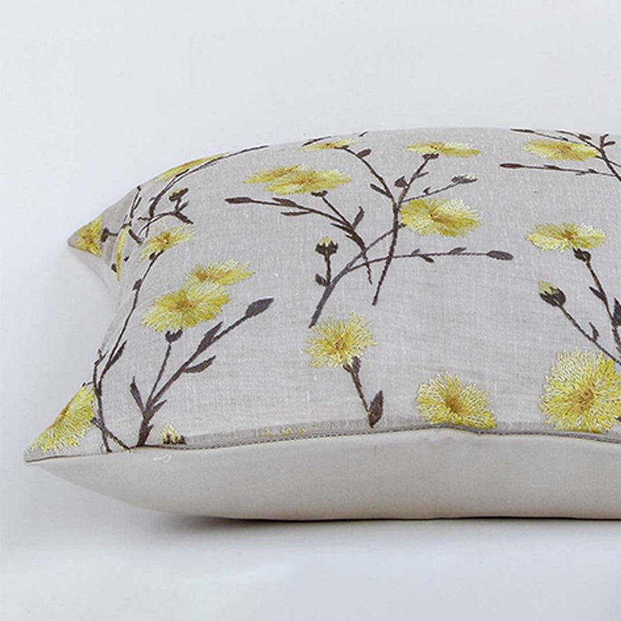 Beige cotton cushion cover with yellow floral embroidery shown in a rectangular shape enhancing home décor with a soft breathable and skin friendly handcrafted texture.