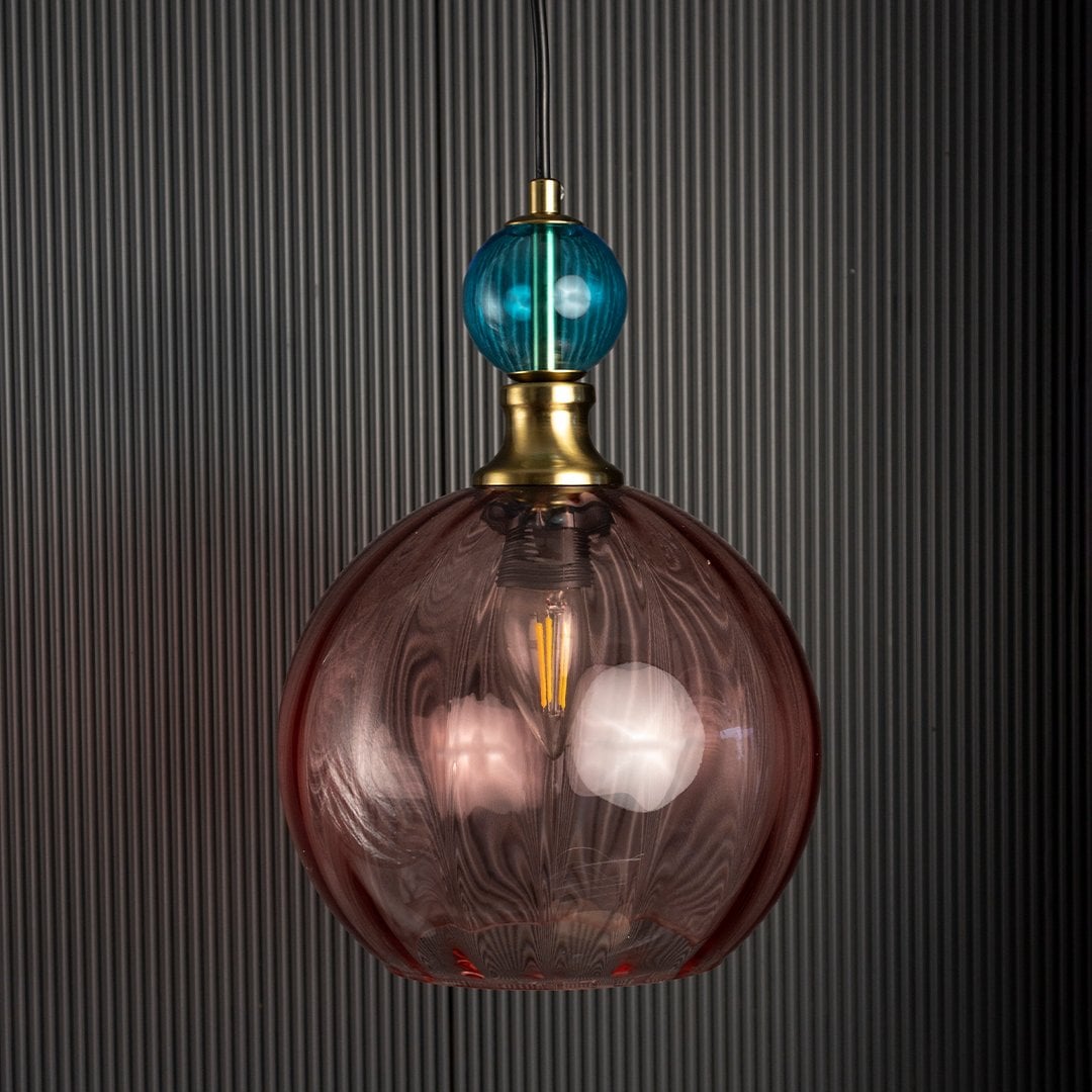 Glass pendant light turned off with amber globe and teal top element highlighting vintage-inspired craftsmanship.