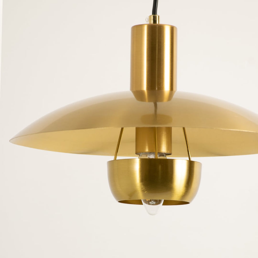 Gold metal pendant light illuminated to display luxury ceiling lighting with elegant modern decorative styling.