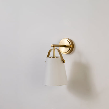 Gold metal wall light with white fabric shade displayed on a white background with light off showing its sleek modern shape and finish.