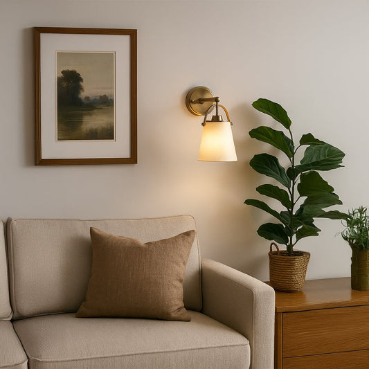 Gold metal wall light with white fabric shade styled in a modern living space creating warm ambient lighting for hallways bedrooms and entry areas.