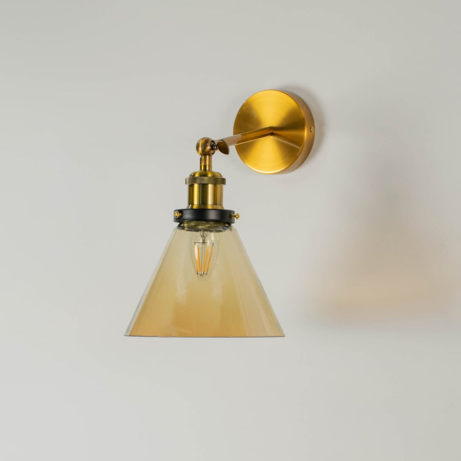 Gold wall mounted pendant light without illumination against a white background focusing on its elegant glass and metal design.