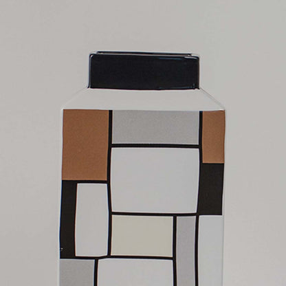 Closeup of ceramic vase with bold geometric square pattern in earthy tones highlighting its modern artistic home decor style.