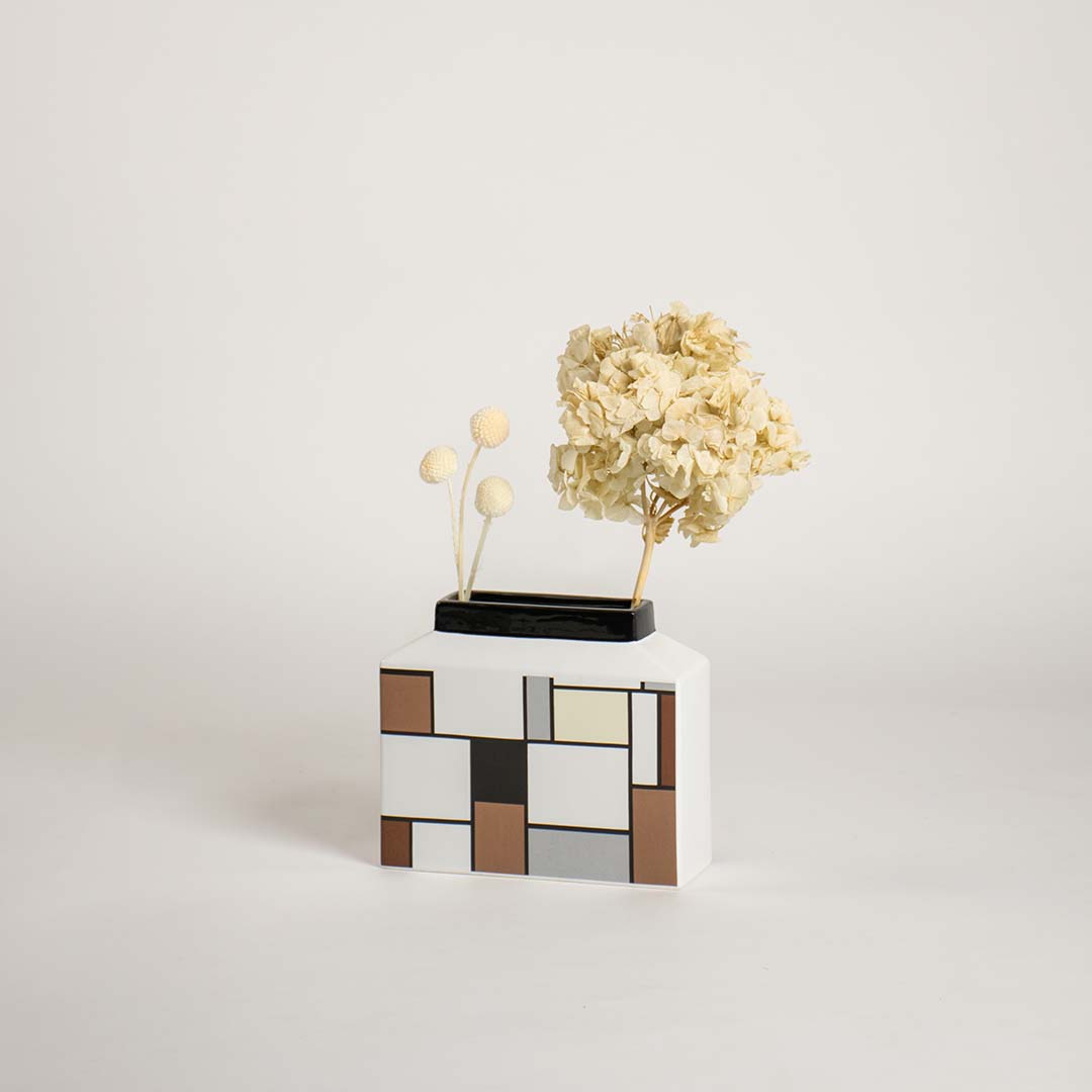 Modern geometric ceramic vase displayed on a plain white background highlighting its clean artistic block pattern design.