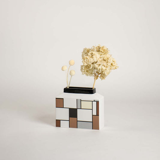 Modern geometric ceramic vase displayed on a plain white background highlighting its clean artistic block pattern design.