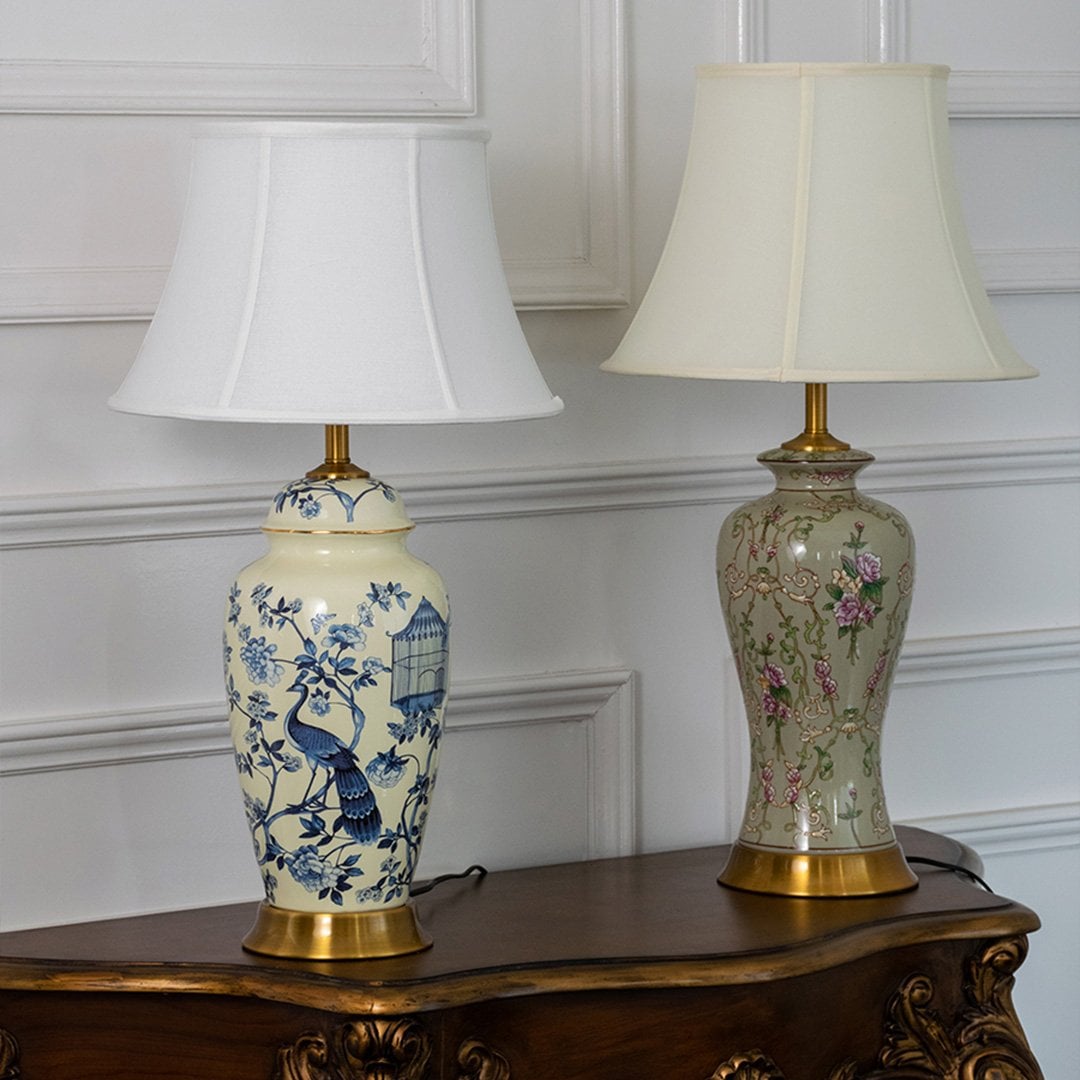 Pair of ceramic lamps with blue floral bird artwork and golden bases styled for traditional luxury home decor.