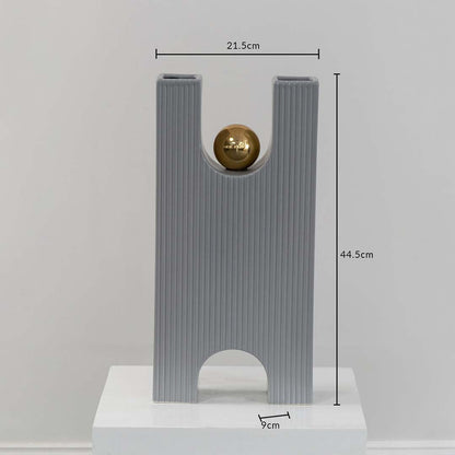 A grey sculptural decor piece with gold sphere displayed with measurements showing 21.5 cm width 44.5 cm height and 9 cm depth for accurate size reference.