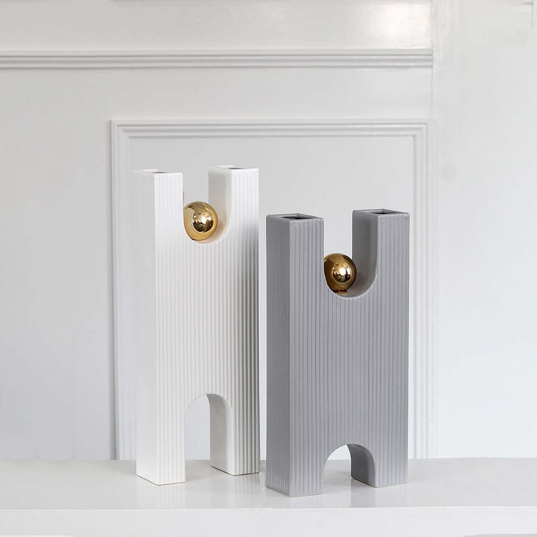A tall grey textured decor sculpture with a gold sphere shown as part of a styled collection highlighting its modern geometric form for elegant interiors.