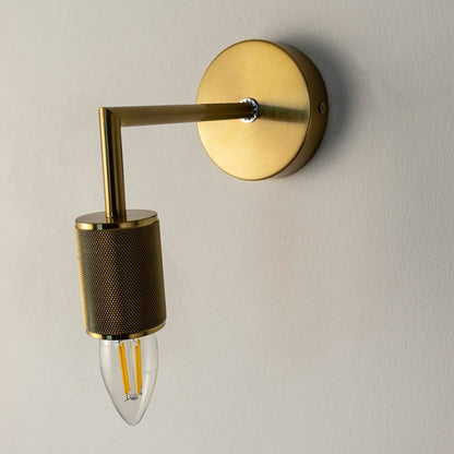 Detailed view of gold wall sconce showing smooth metallic texture and bulb design for luxury interior lighting.