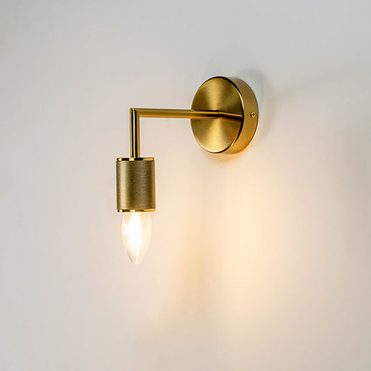 Gold wall light with textured cylindrical holder glowing warmly on white background perfect for modern interiors.