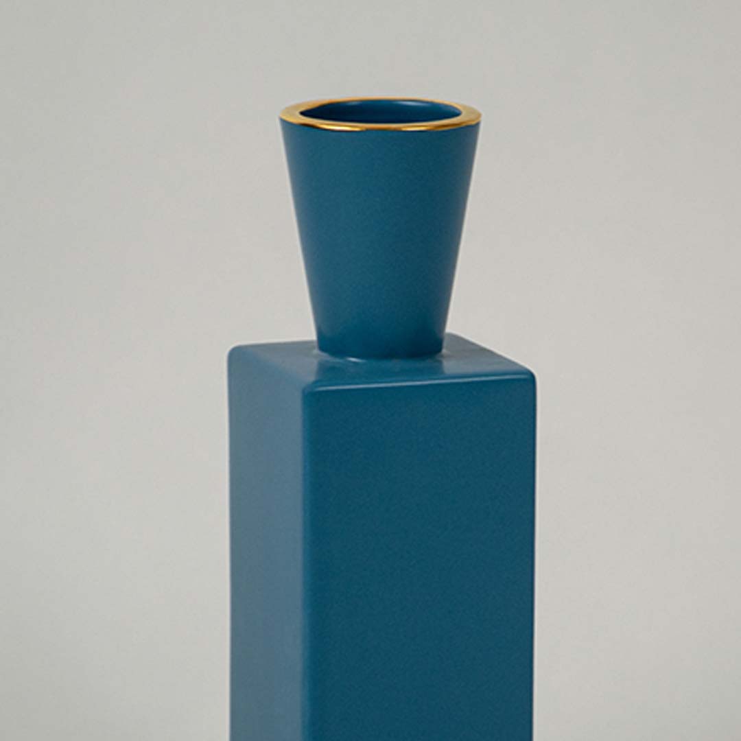 A detailed closeup of the blue geometric ceramic vase showing its matte texture  tapered neck  and clean lines for a modern decorative look.