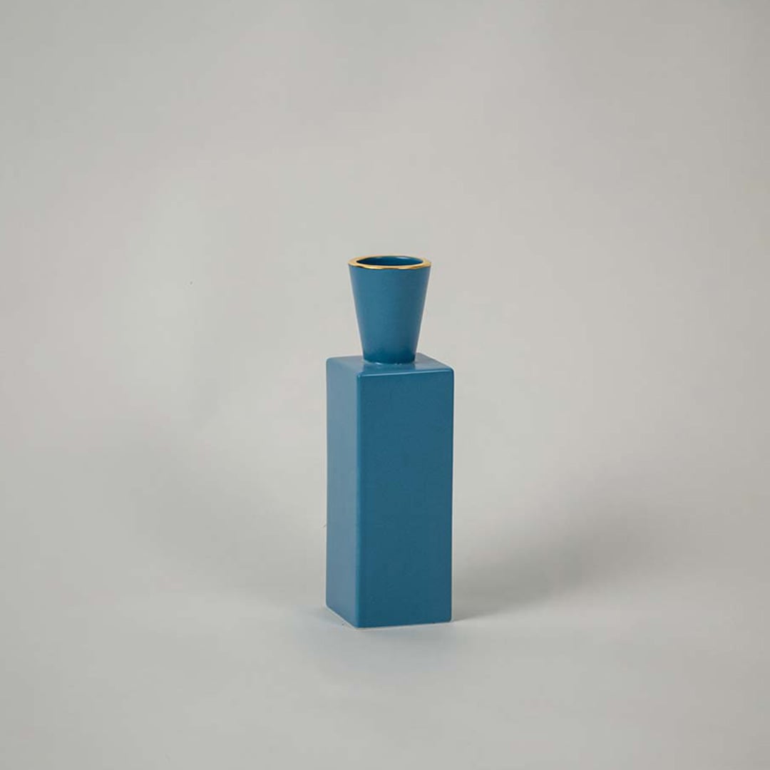 A contemporary blue ceramic vase photographed on a white background  emphasizing its tall rectangular form and refined minimal style.