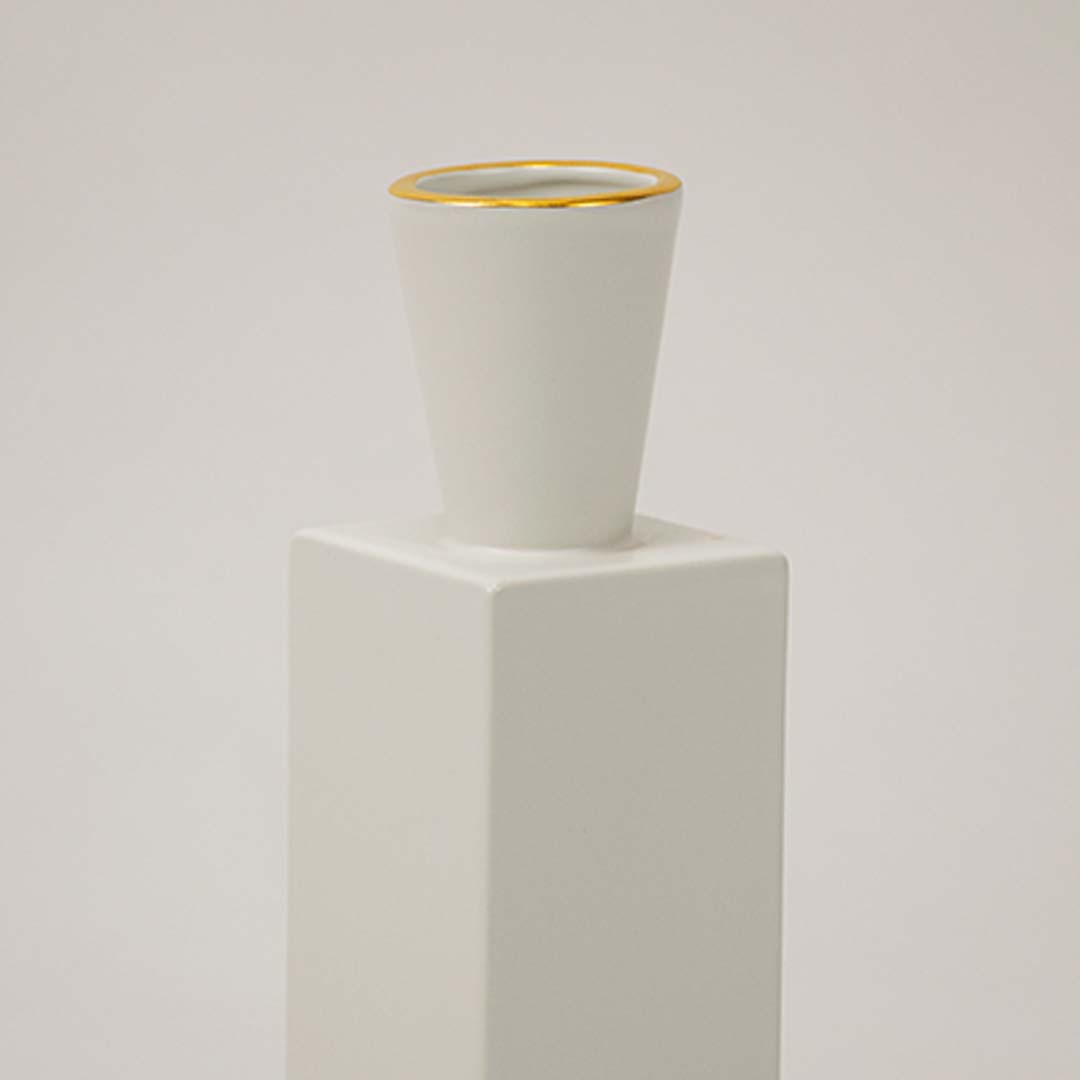 Closeup of white ceramic vase featuring a gold rim and smooth matte finish ideal for modern elegant home styling.