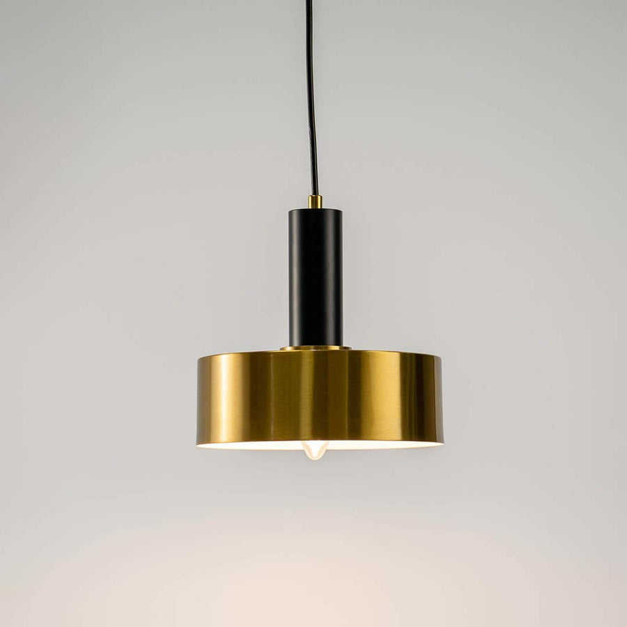 Black and brass metal pendant light with layered disc design for elegant contemporary home decor spaces.