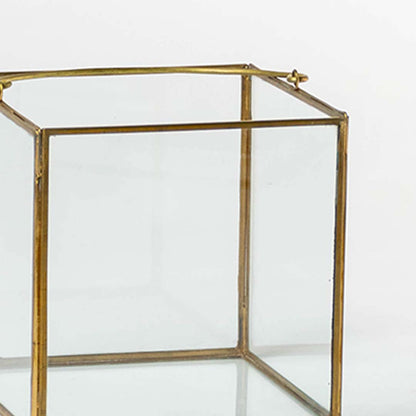 Closeup of gold metal frame lantern with clear glass panels for elegant modern decor styling use.