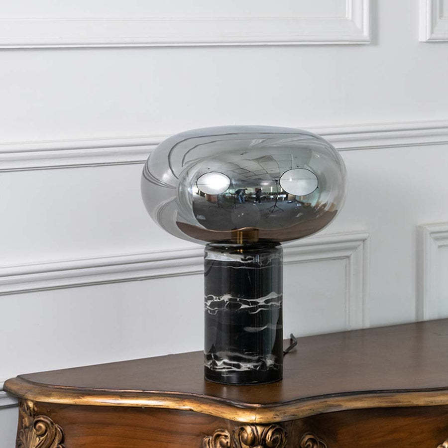 Elegant smoked glass table lamp with a solid black marble base displayed on white background showcasing its sleek modern design.