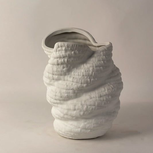 Side angle view of white ceramic sculptural vase with unique textured surface and curved rim ideal for modern home interiors.